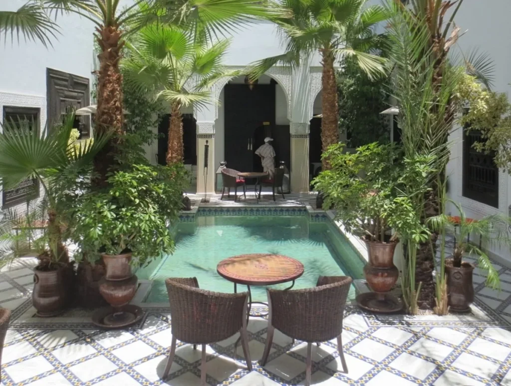 Moroccan riad courtyard with pool and palm trees